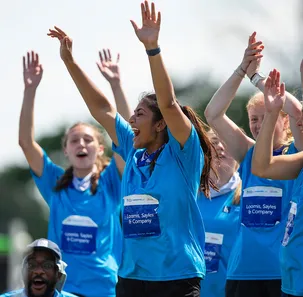 A group of Corporate Cup event participants shouting happily with their hands in the air